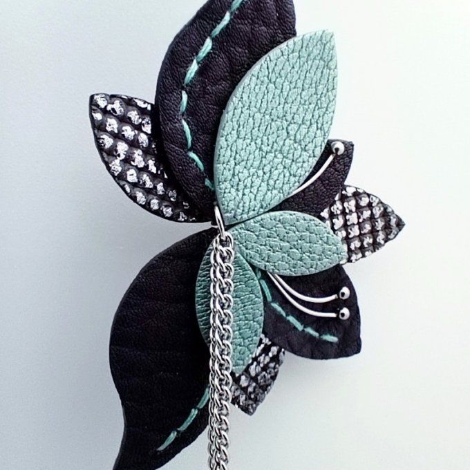 Détail de la fleur Amaryllis Mirage (violet, turrquoise) en cuir cousu main et chaînes fines.