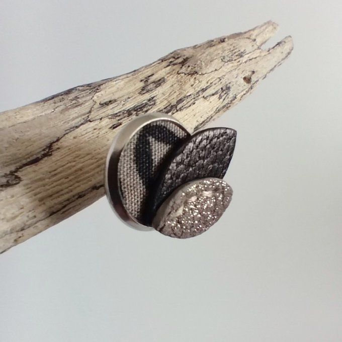 Gros plan sur une boucle d'oreille Pétales de lune - Sable cendré, détail profil du tissu et cuir