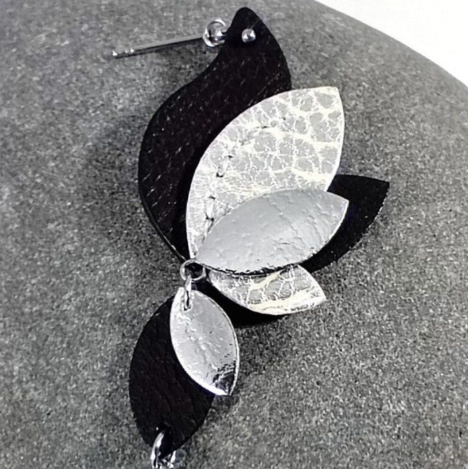 Zoom sur la boucle gauche, ornée d’un motif floral en cuir noir et argenté, soulignant le contraste 