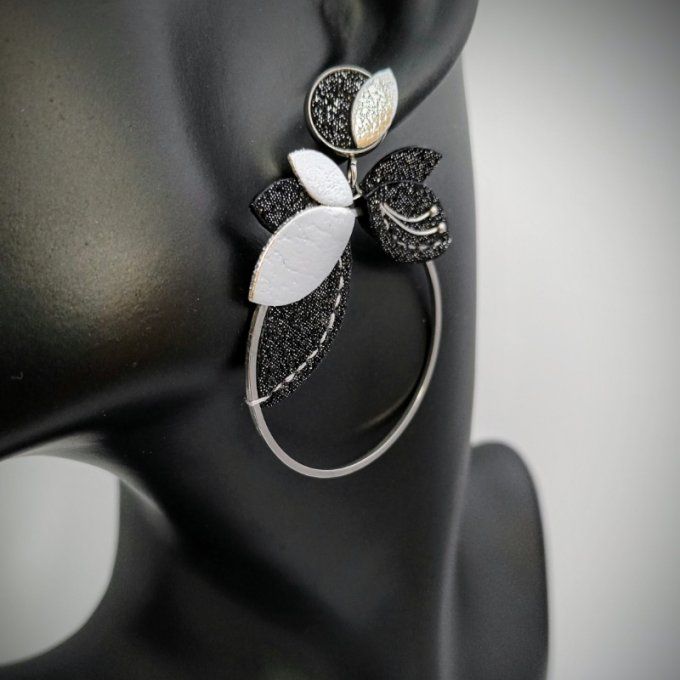 Boucle d’oreille Orphée Galaxie portée : anneau orné d’un feuillage en cuir noir pailleté et argenté