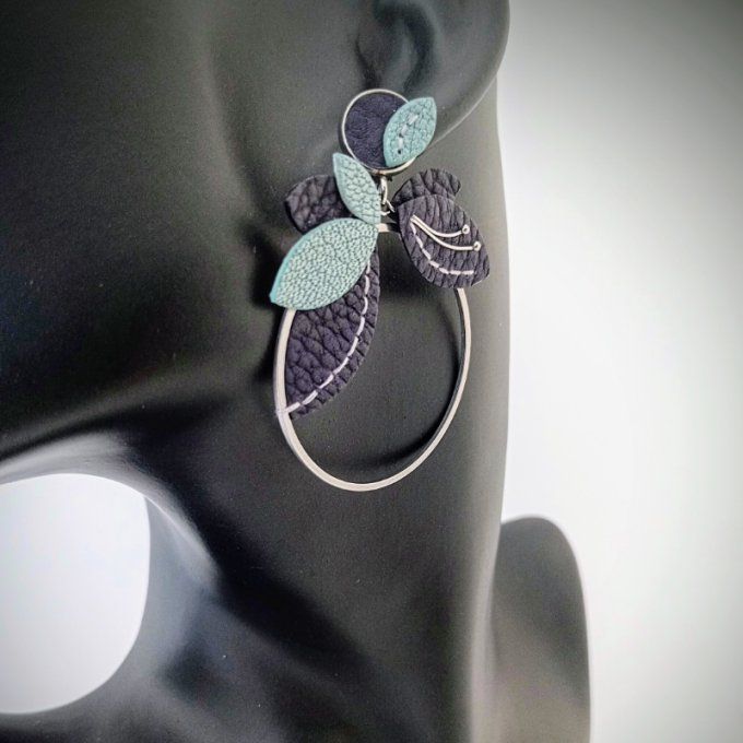 Boucle d’oreille Orphée Mirage portée : anneau ornée de feuillage en cuir, aux reflets turquoise nac
