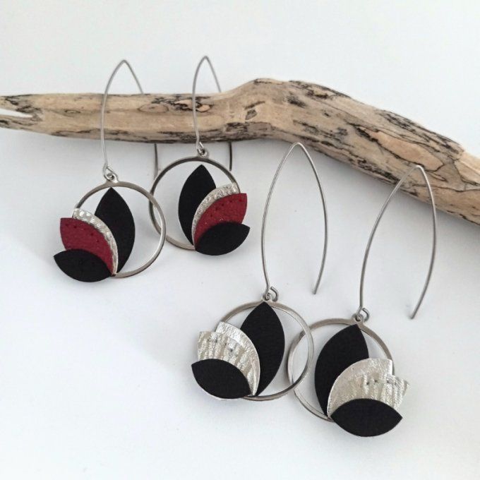 Les deux versions des boucles d’oreilles Calista présentées ensemble : Éclipse (noir et argent) et R