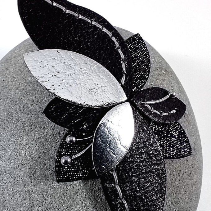 Zoom sur les détail de la boucle d'oreille Lys noire et argentée cousue main.