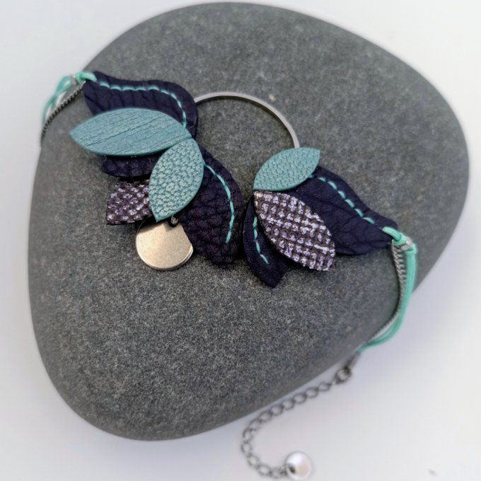 Bracelet Nymphéa Mirage : feuilles cuir violet et turquoise cousues main sur anneau argenté, posé su