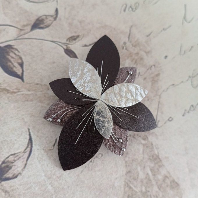 Broche Luna Bloom Ombre Givrée en cuir argenté et sable, posée sur fond romantique avec écritures ma