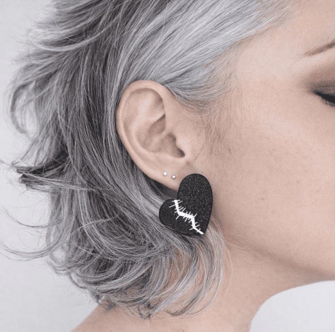Clou d'oreille coeur fendu noir et argent sur modèle