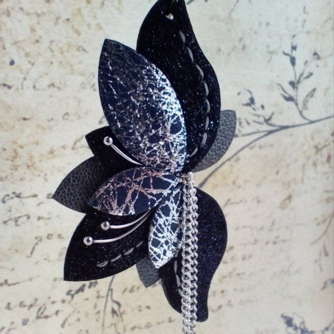 Zoom sur une boucle doreille Amaryllis. Détail des cuirs marine pailleté, bleu et argenté, ornements