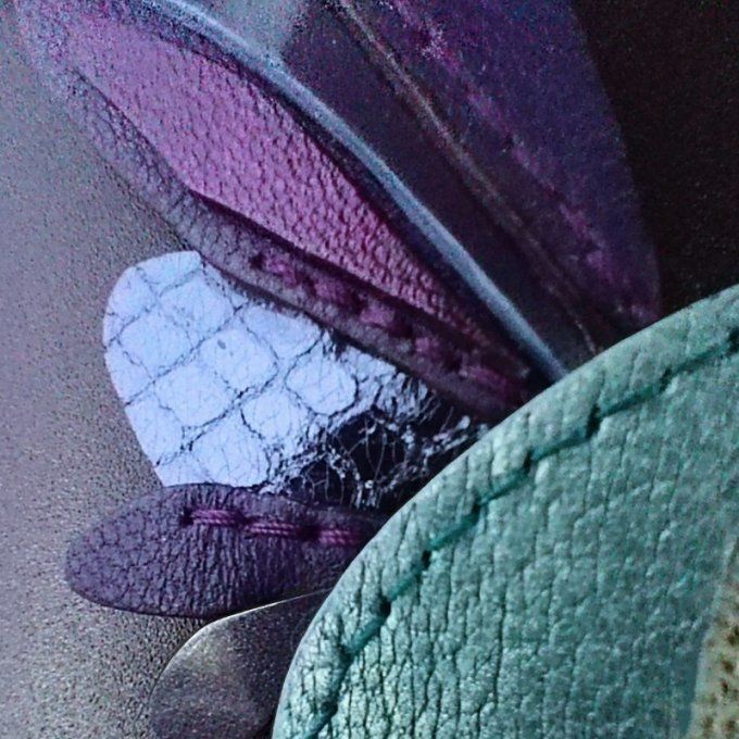 Zoom sur les plumes du colibri multicolore en cuir : textures nacrées et métalliques, coutures faite